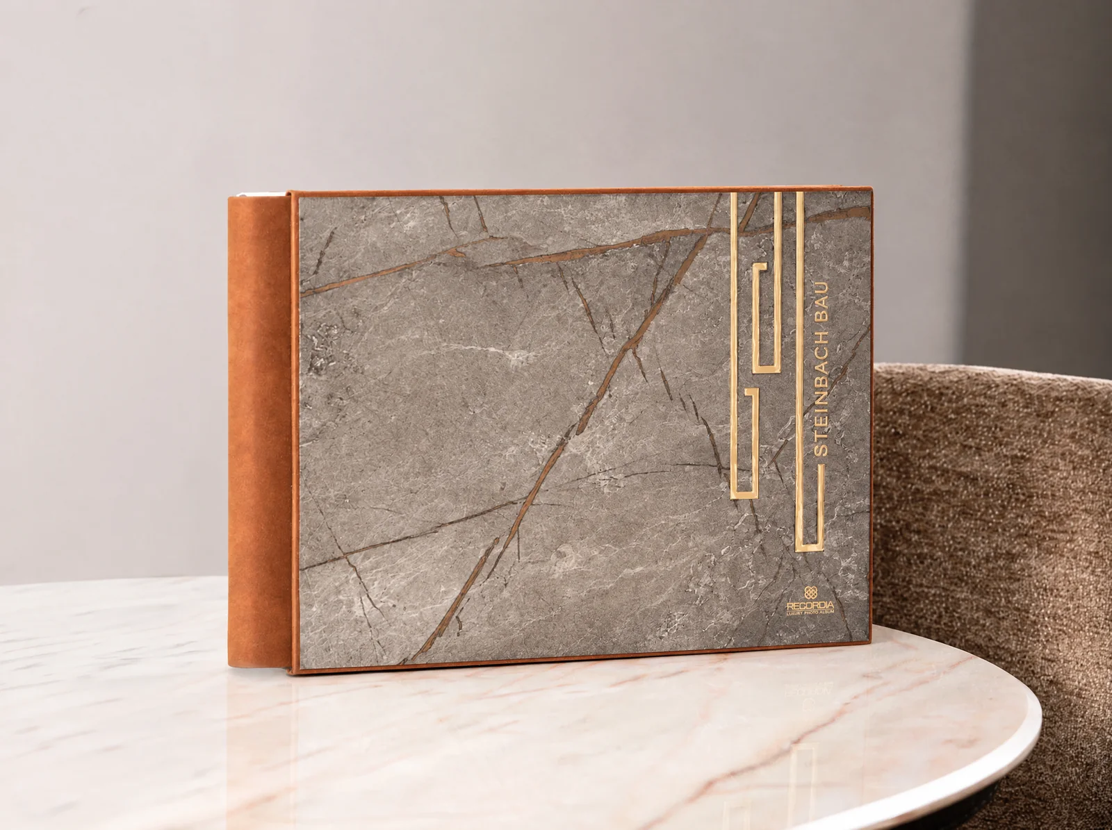 Fotobuch mit Cover in Steinoptik, goldenen Metallelementen und Firmenschriftzug